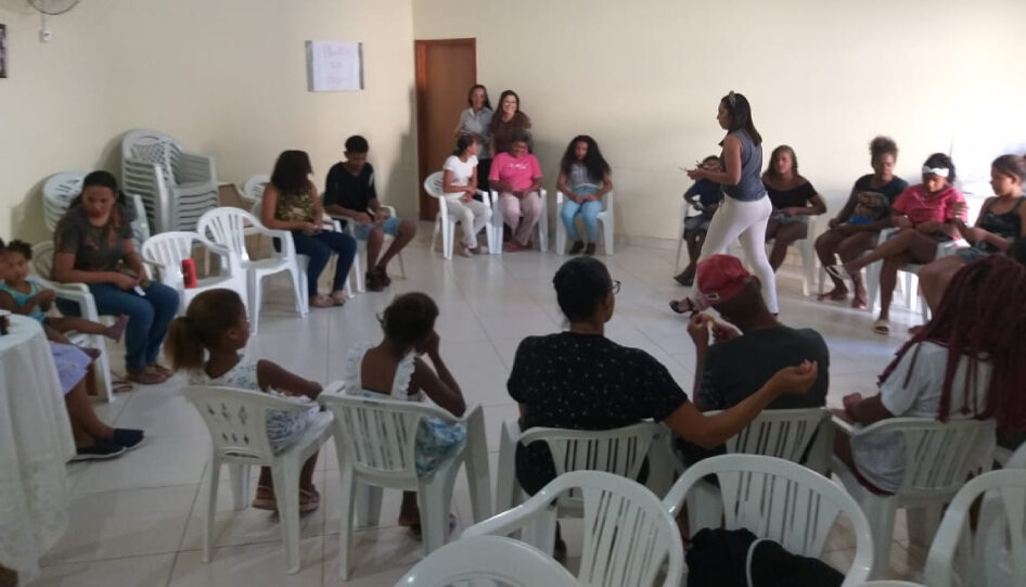 Grupo de pessoas sentadas em círculo, participando de uma dinâmica.